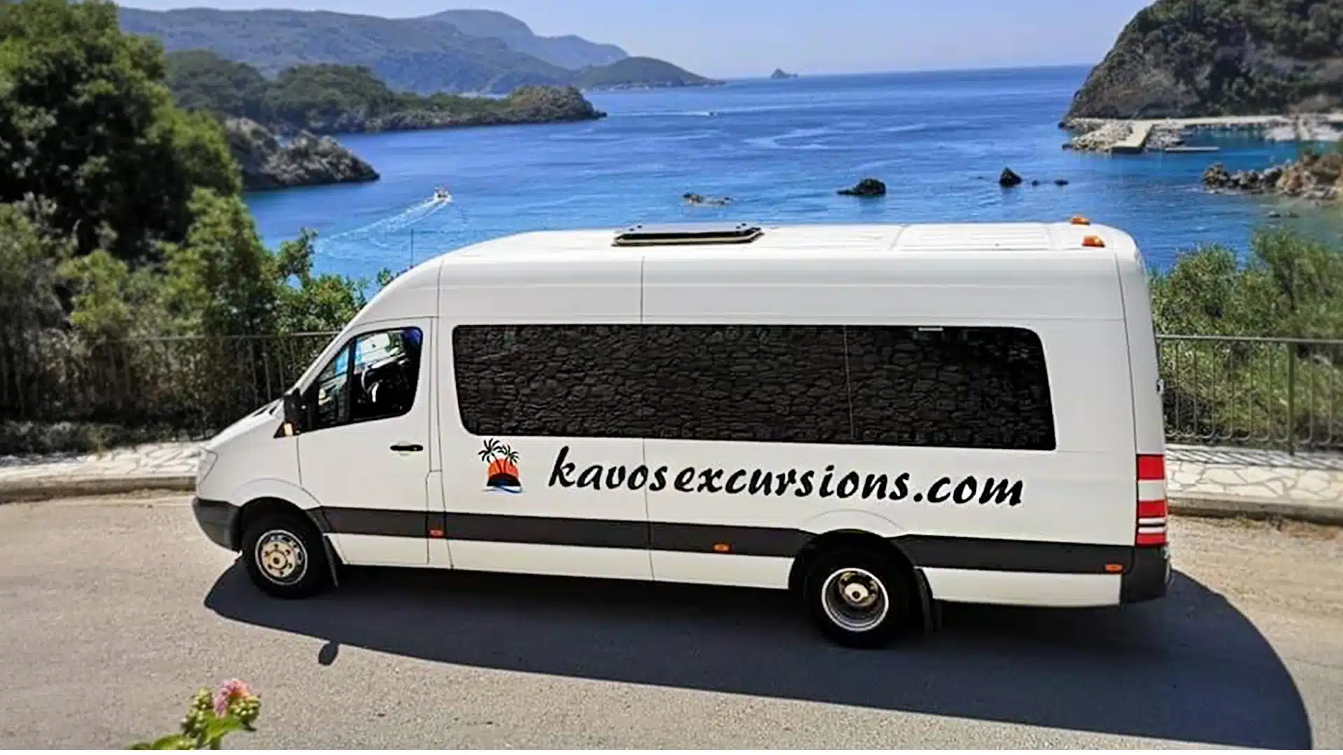 a kavos excursions mini bus parked in front of a beach
