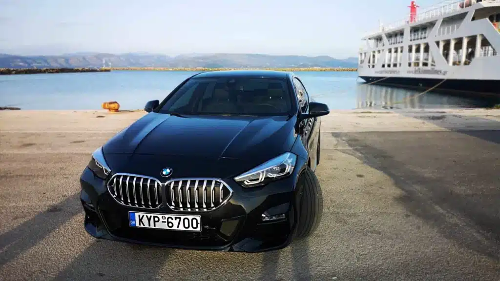 bmw M220 parked in front of a ship